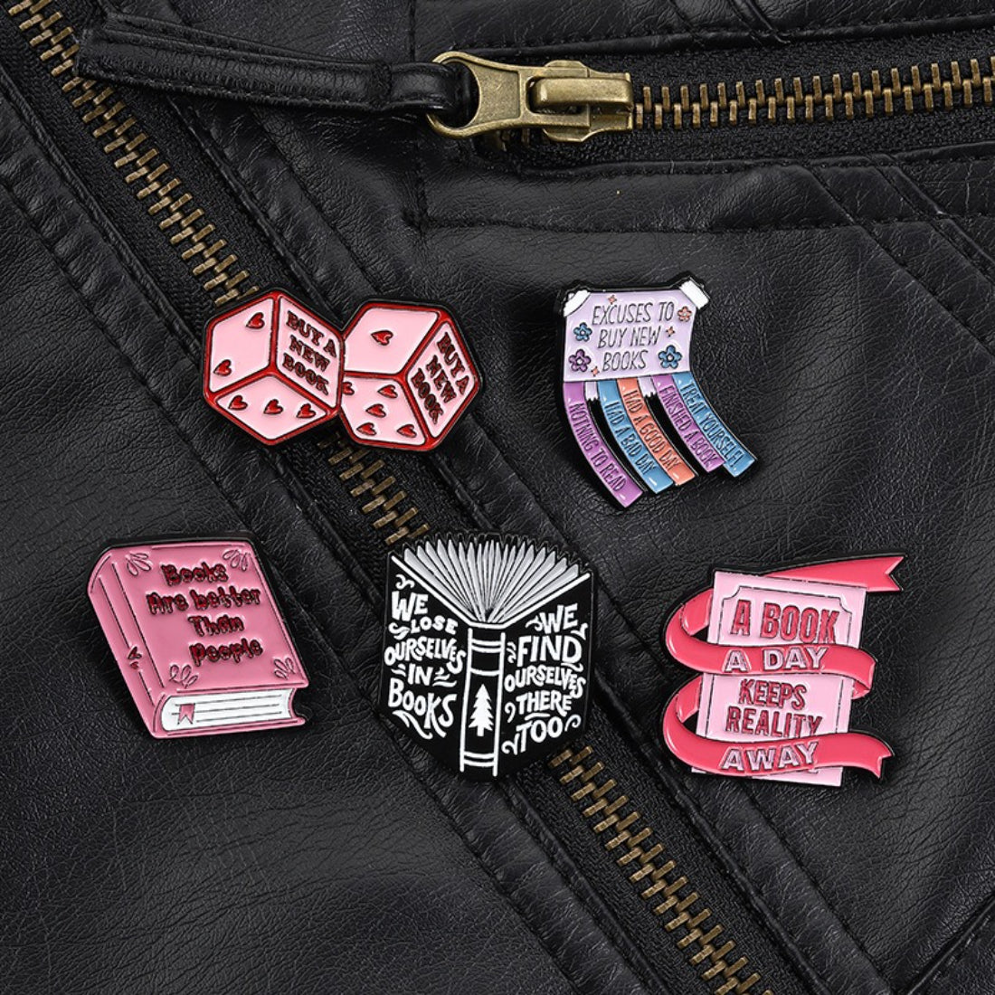 Pinori Book Lover enamel pin photographed with a stack of books in the background
