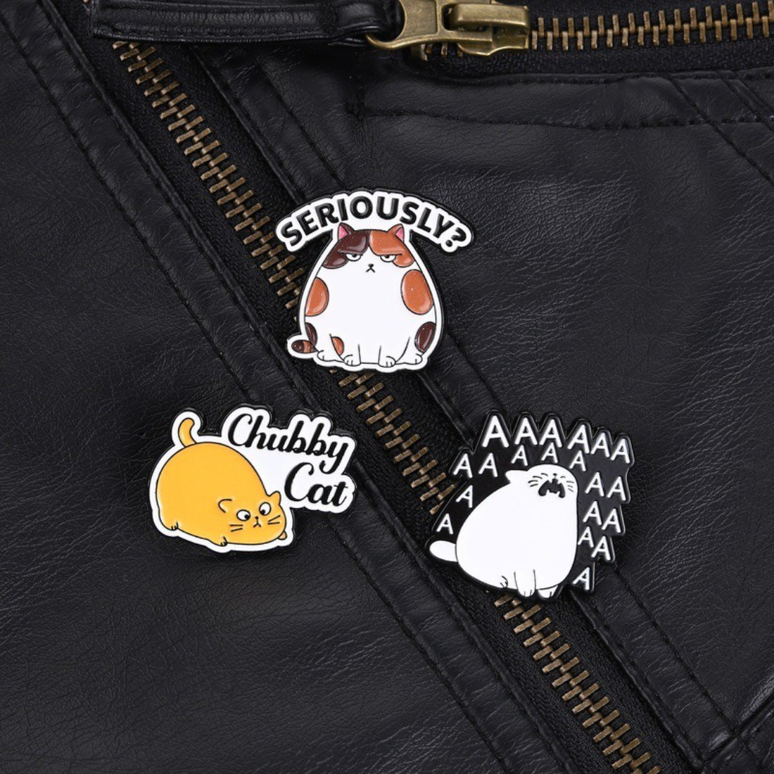 Pinori chubby cat mood enamel pin next to a ruler for size reference