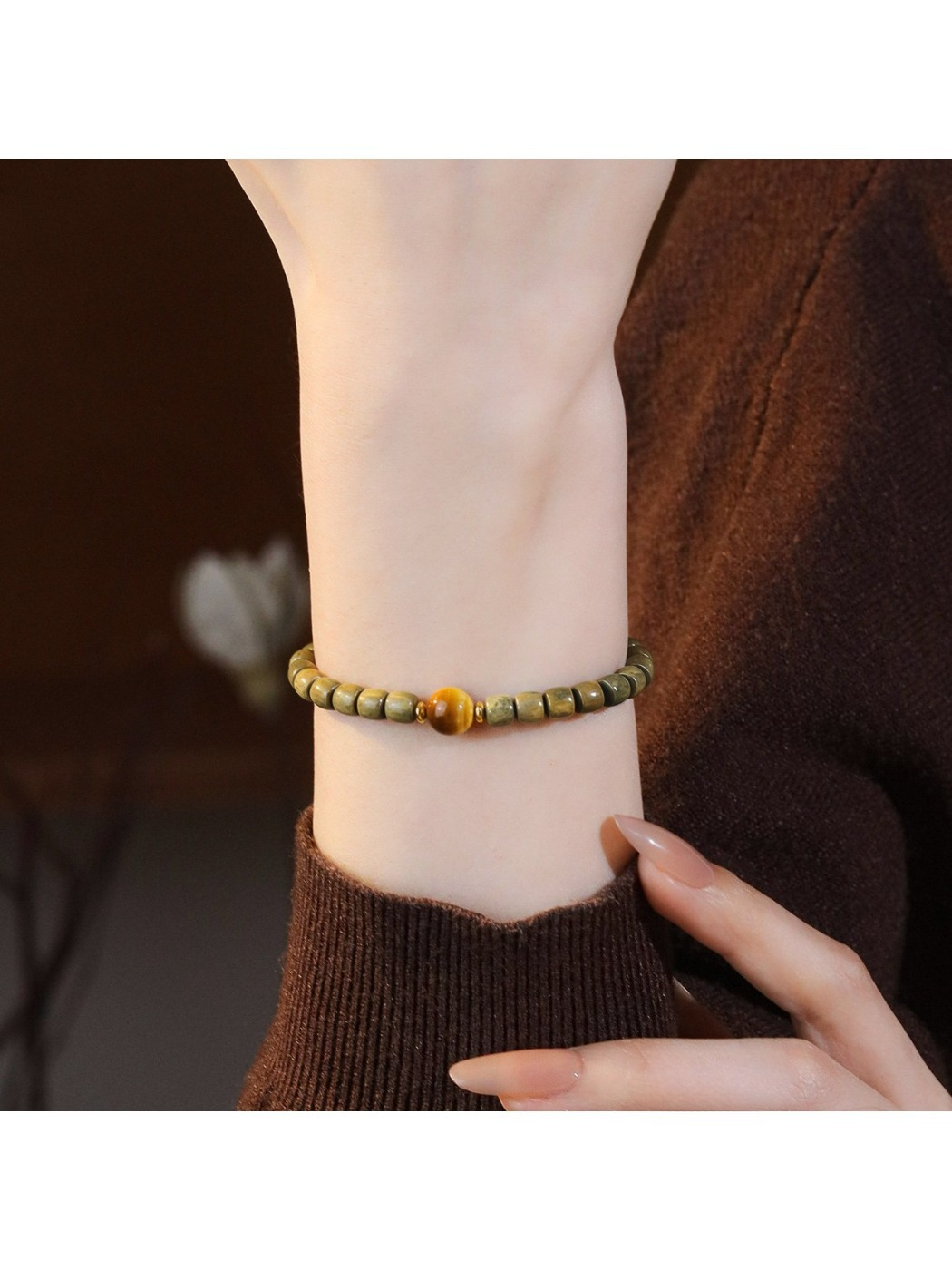 Detailed shot of green sandalwood beads and cat eye stone on Emora bracelet