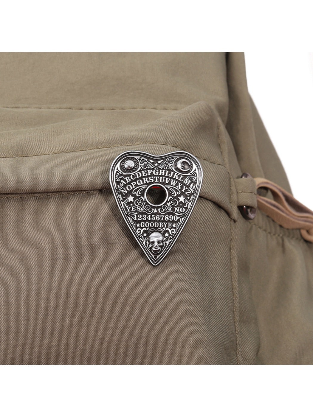 Pinori black metal heart pin badge attached to a backpack strap
