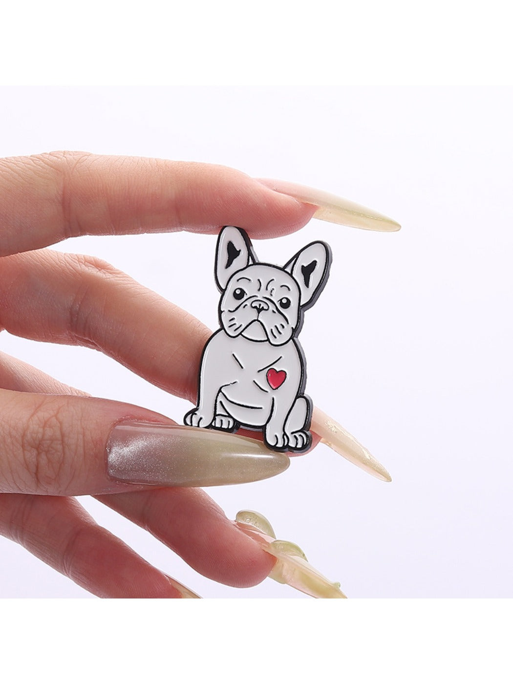 Pinori cartoon pug brooch next to a ruler for size reference
