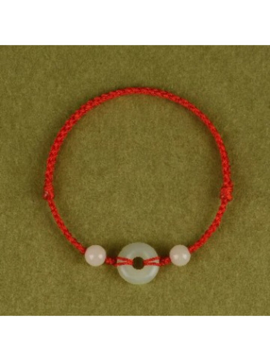 Close-up of Emora Peace Knot red string anklet with silver knot charm on wrist