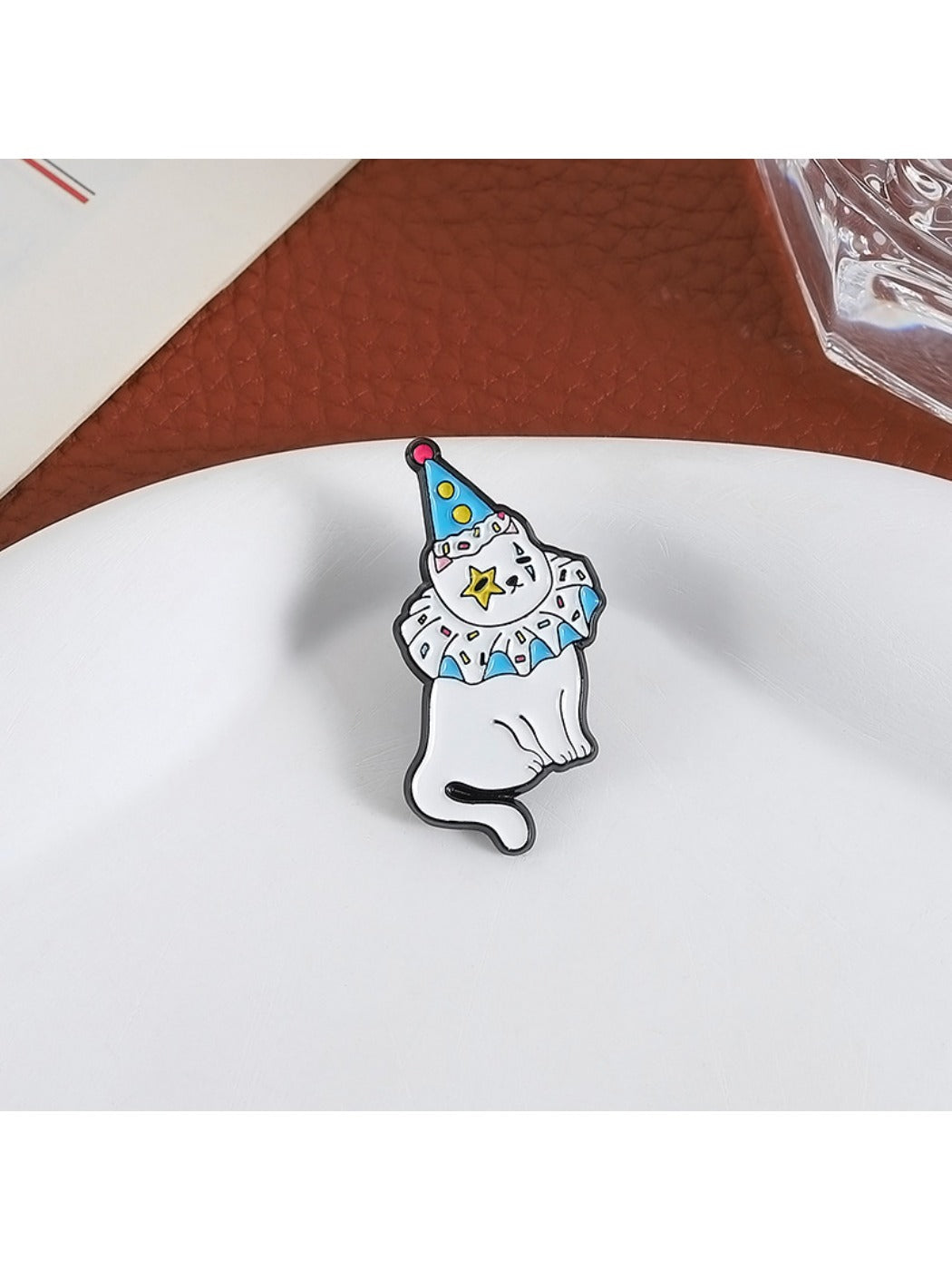 Close-up of Pinori cartoon kitten pin showing detailed enamel colors and facial features