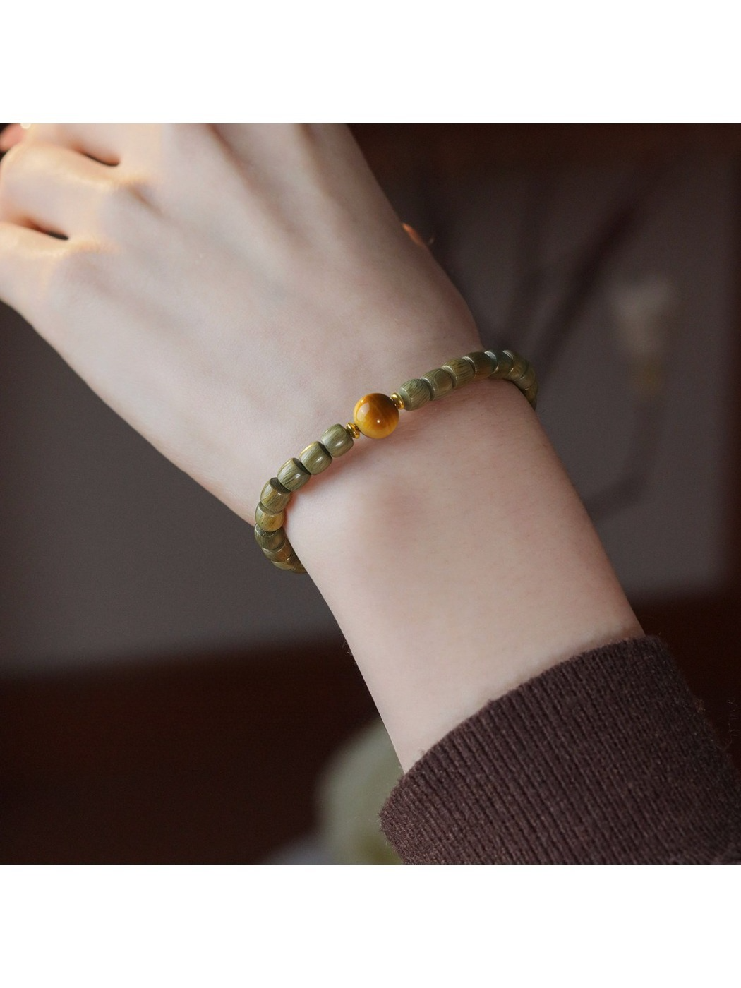 Side view of Emora sandalwood bead bracelet highlighting smooth cat eye stone