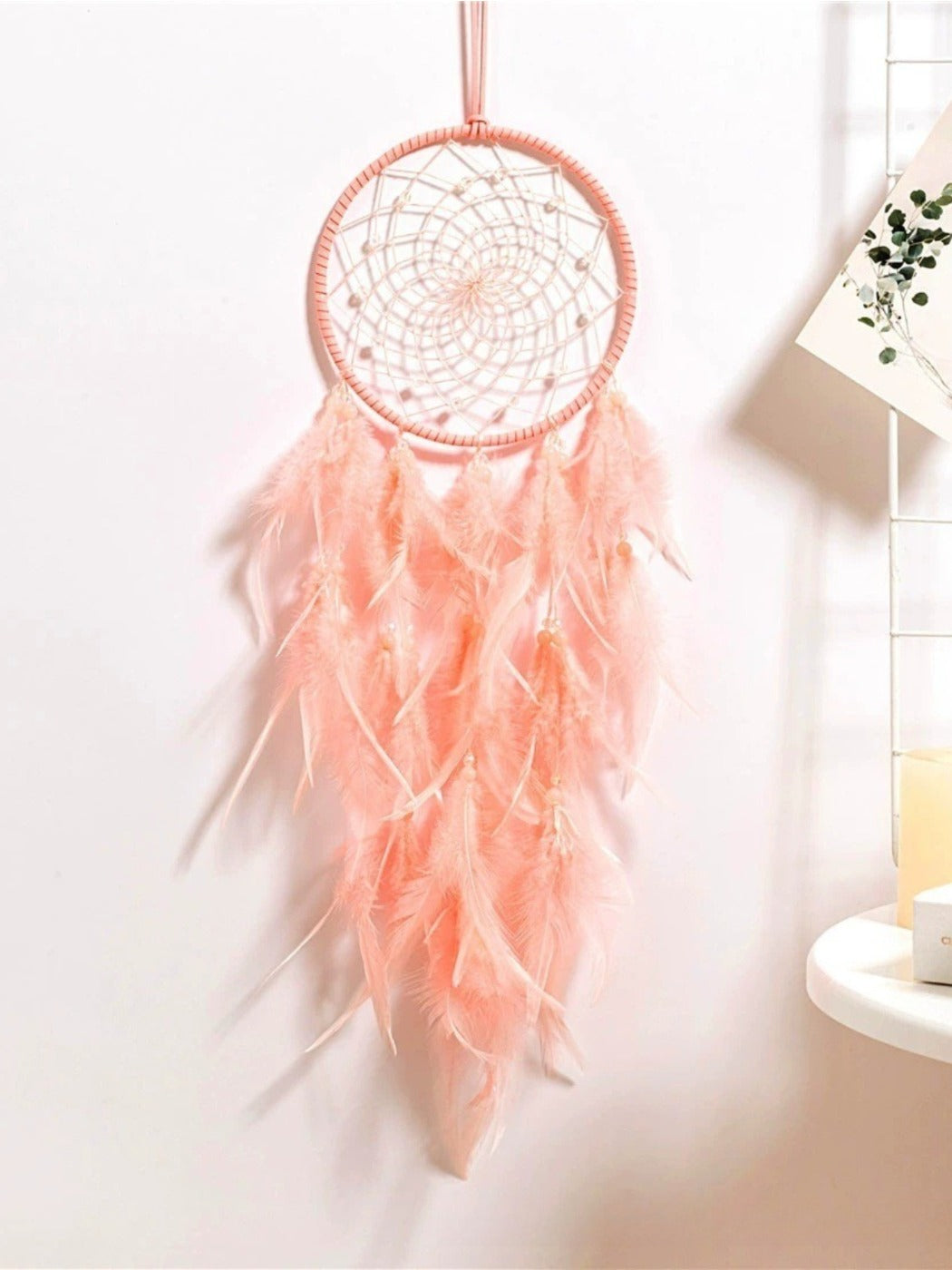 Close-up of dreamcatcher web with intricate weaving and colorful beads on wind chime