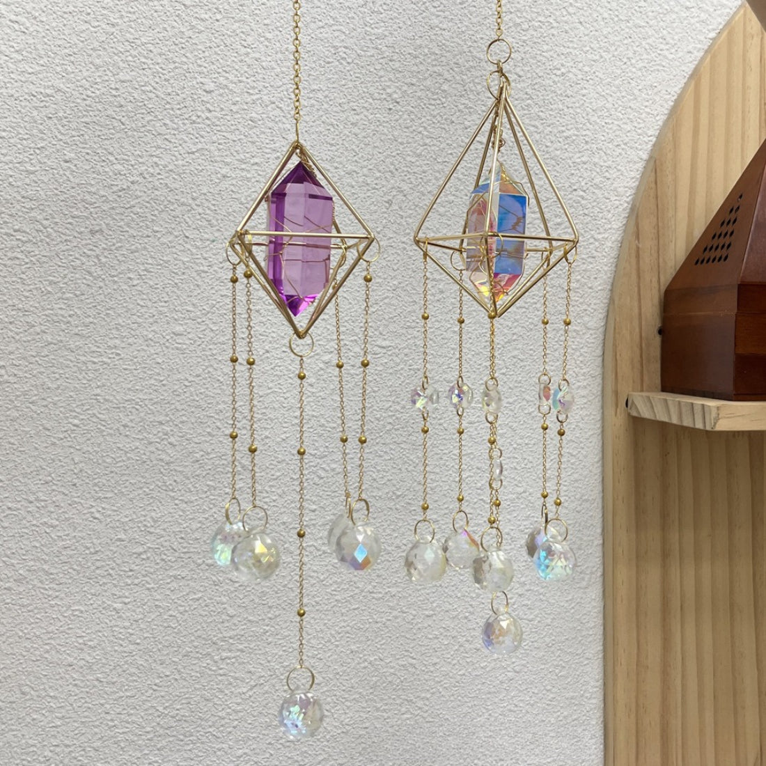 Close-up of Somnira geometric prism suncatcher showing metal edges and glass detail