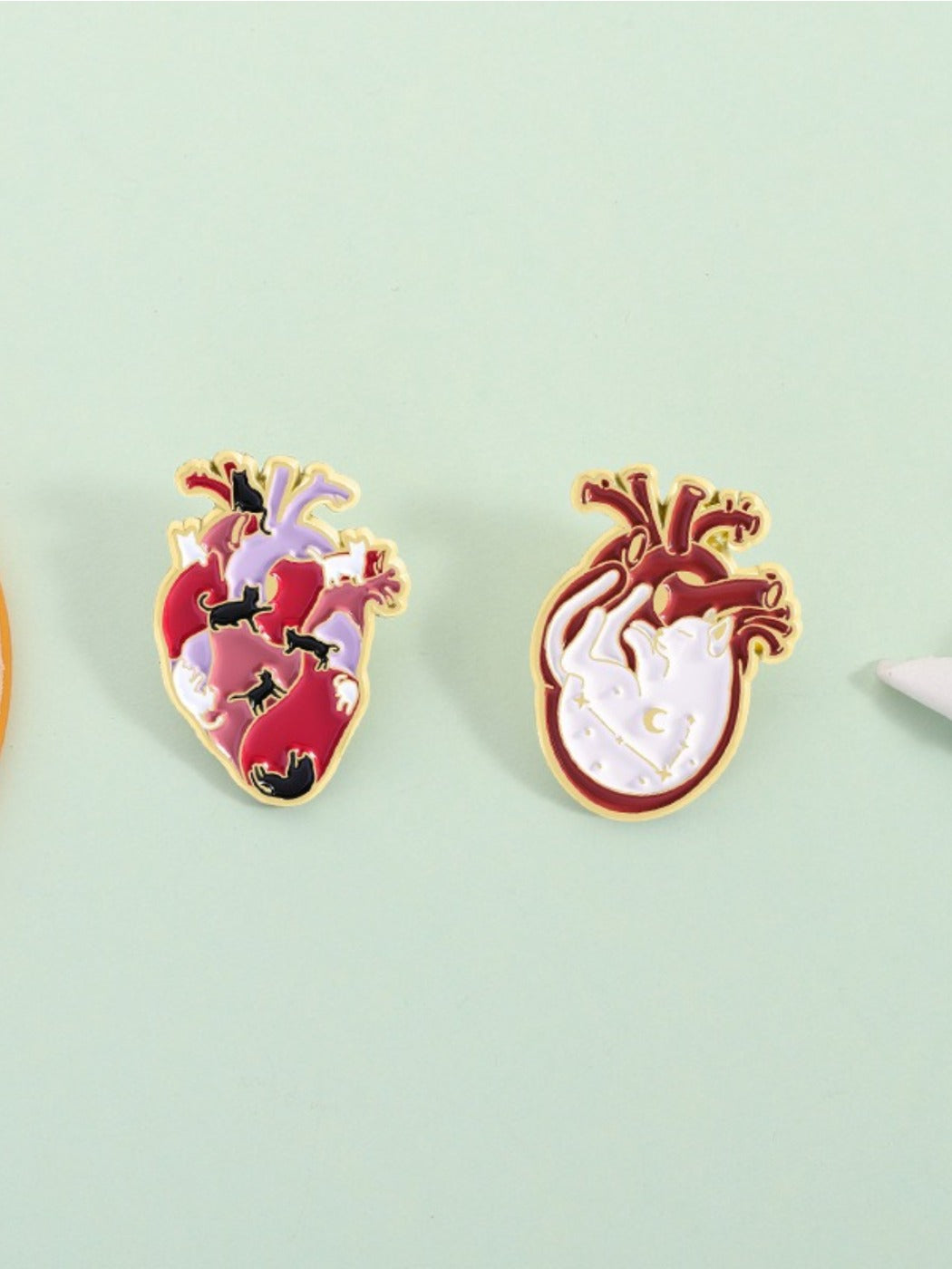 Side view of Pinori cat heart anatomy brooch displaying metal texture and finish