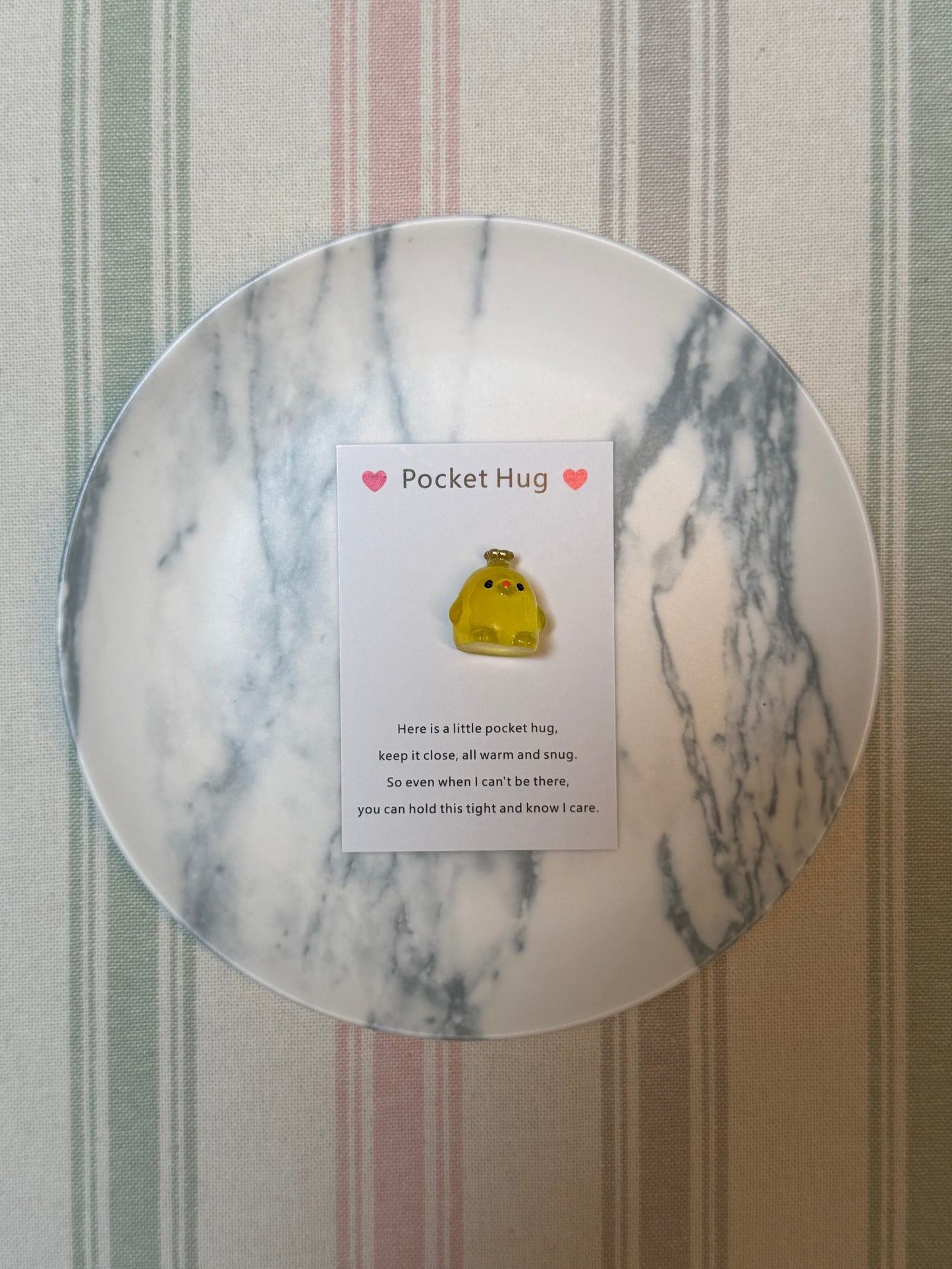Pocket hug card and glow-in-the-dark token displayed together on a flat surface