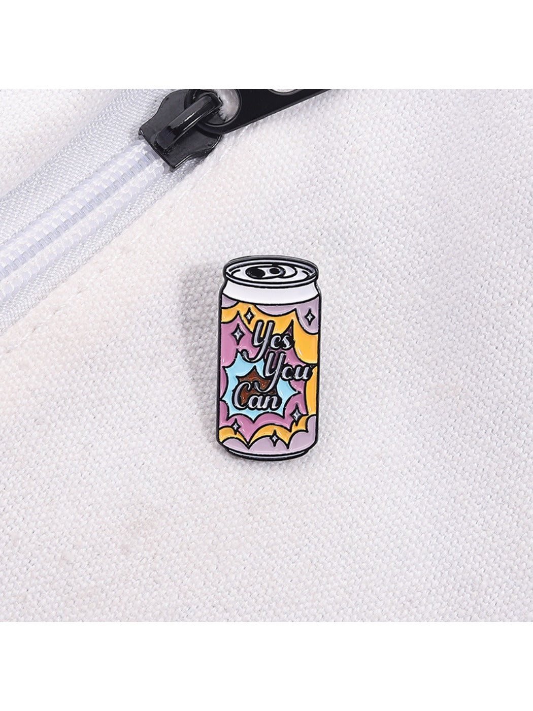 Multiple Pinori punk soda can metal pins arranged in a row on a white surface