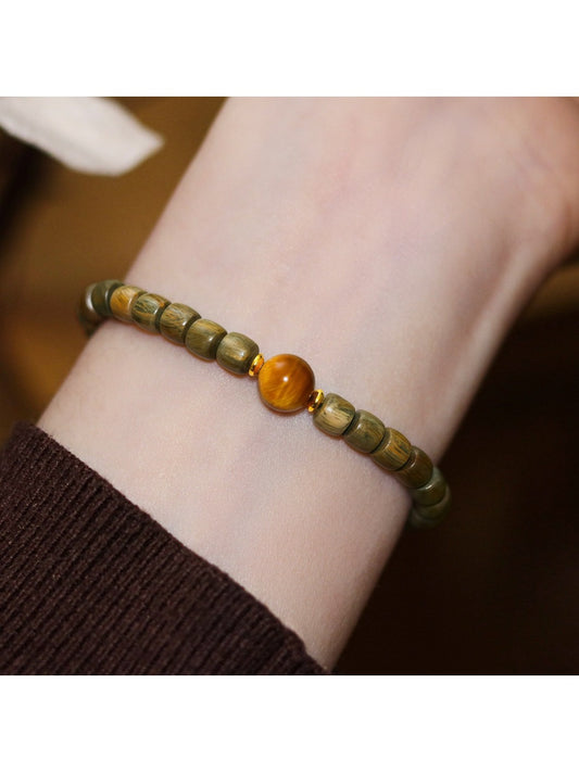 Close-up of Emora green sandalwood bead bracelet with cat eye stone centerpiece