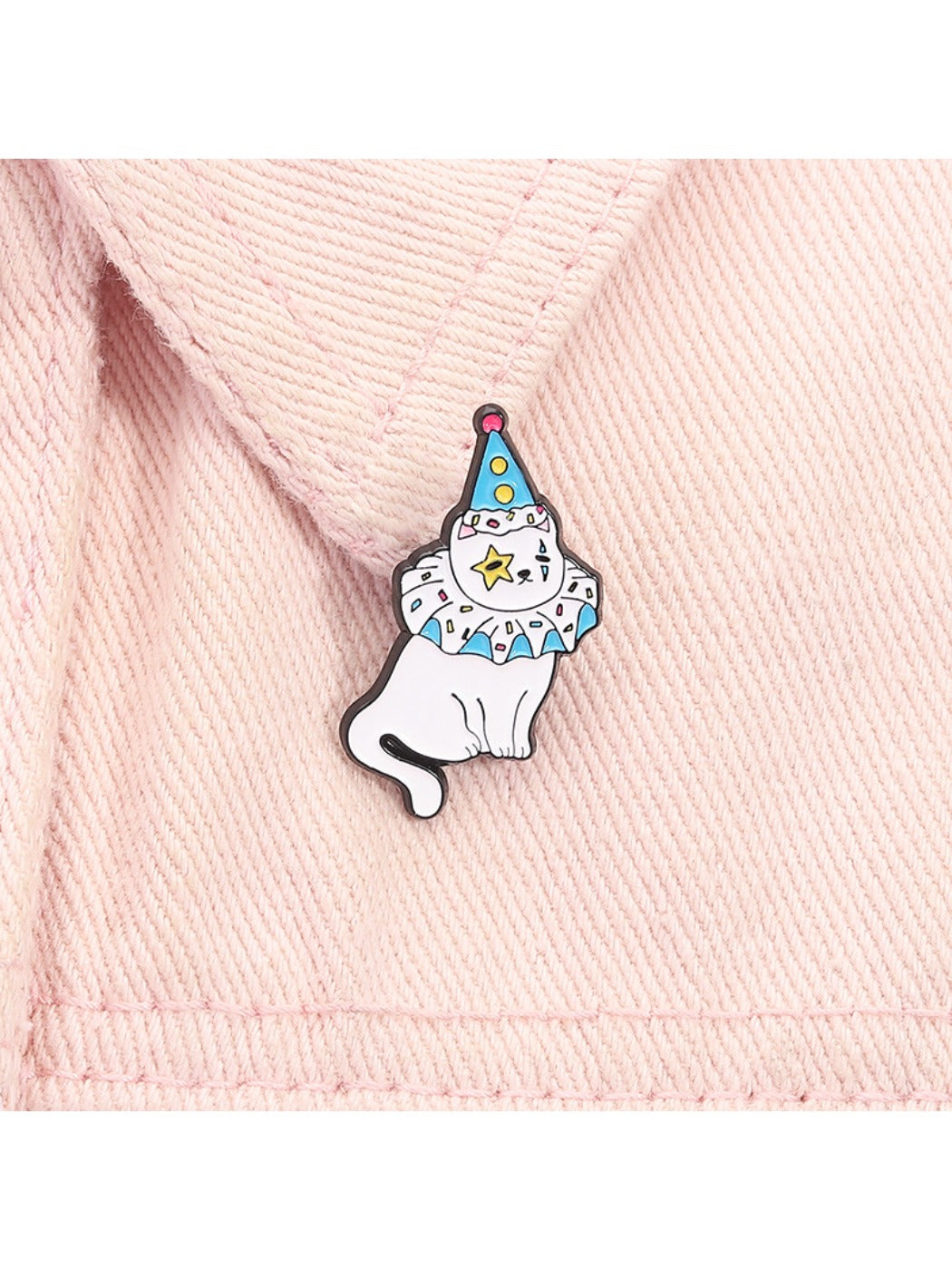 Pinori kitten pin displayed on fabric, showing size and vibrant clown costume details
