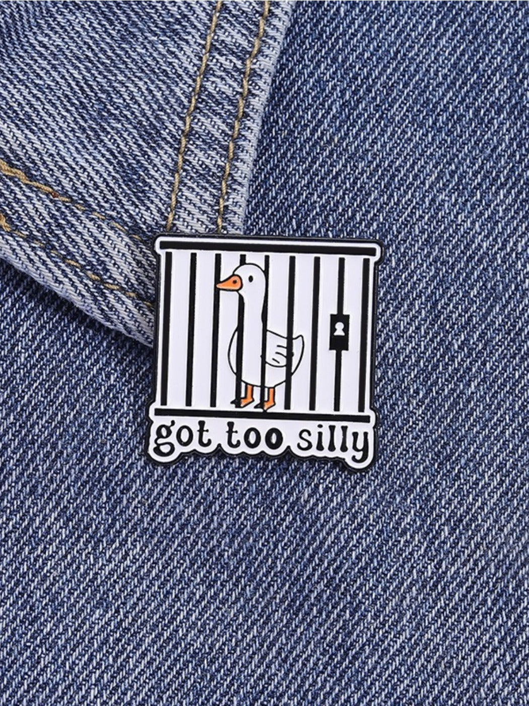 Pinori silly goose enamel pin next to a ruler for size reference on a white background