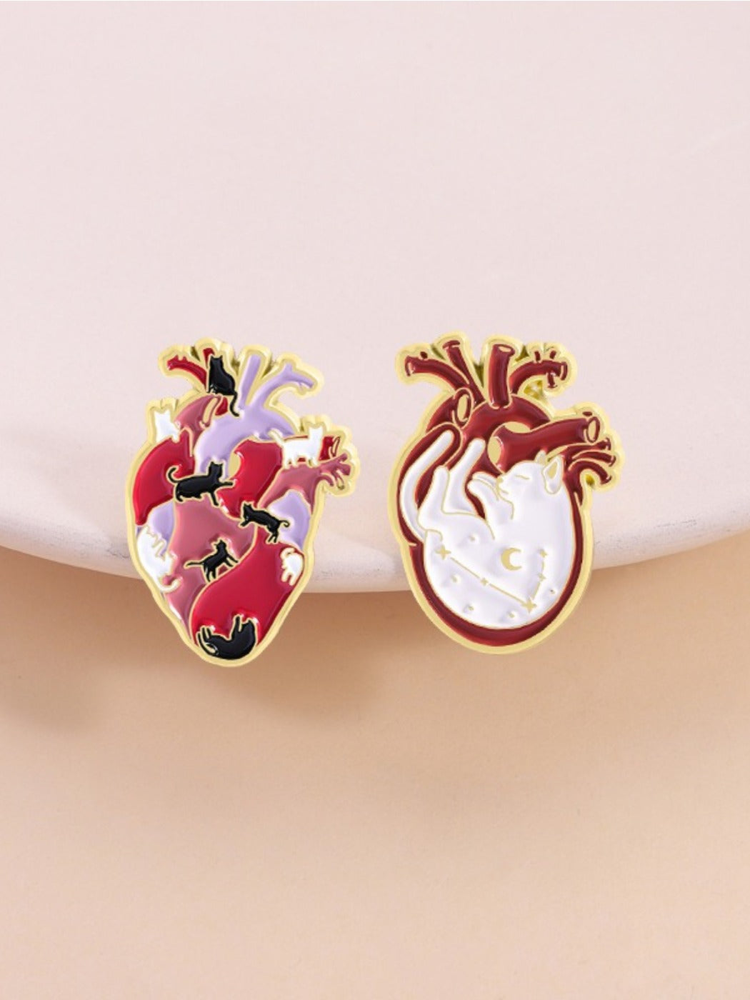 Pinori brooch worn on a jacket lapel featuring cat with heart anatomy design