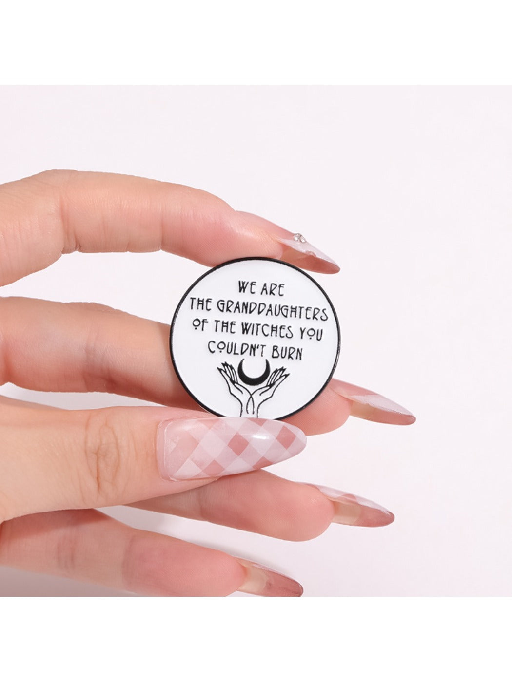 Girl Power Unburnable Badge Pin held between fingers showing size and detail