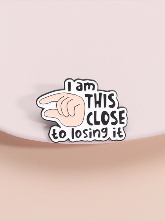 Pinori pin badge with 'I Will Close It' English letter design and finger illustration