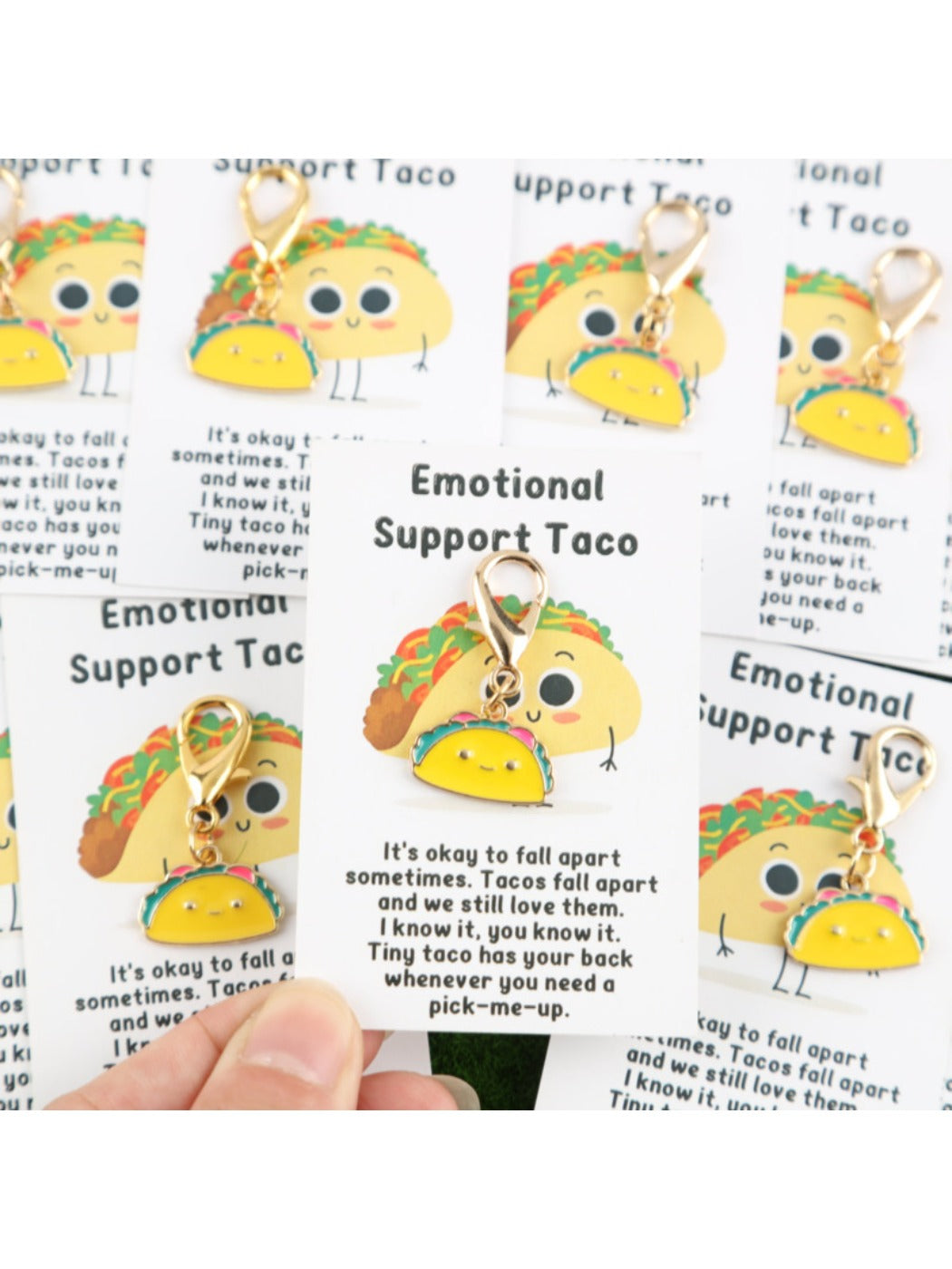 Set of 10 taco-shaped keychains arranged on a white background
