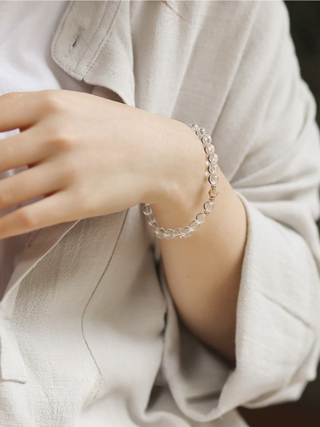 Emora white crystal bracelet displayed on a wooden surface with natural lighting