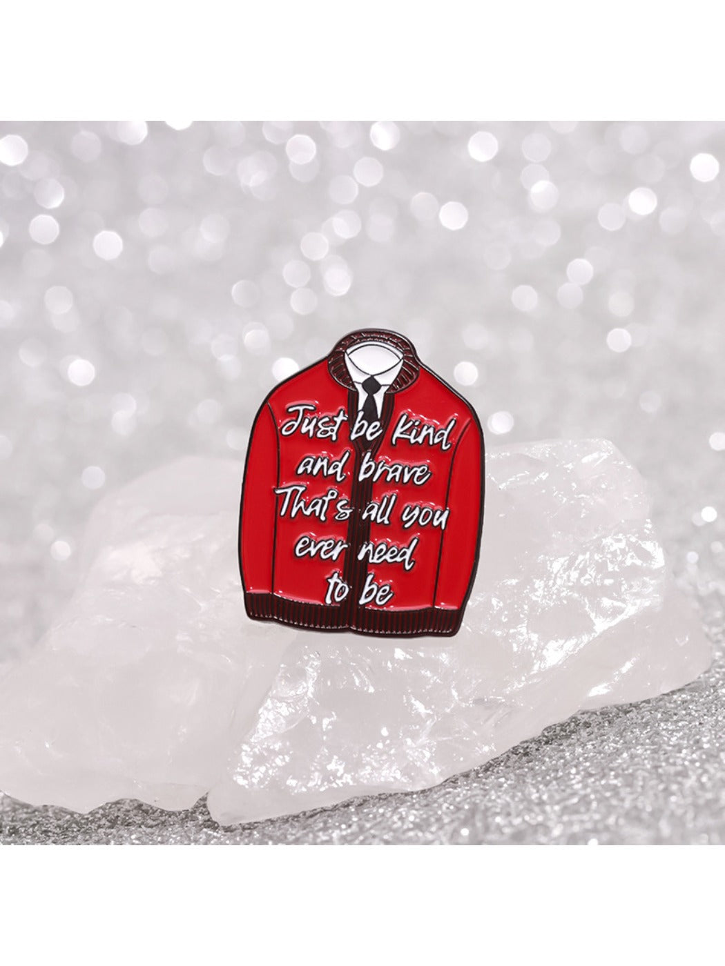 Hand holding Pinori red fashion pin showing front design