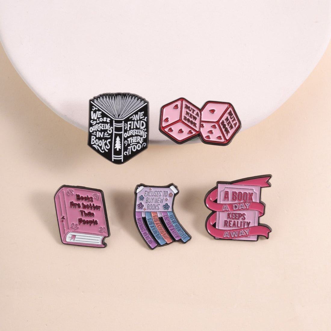 Pinori Book Lover enamel pin featuring an open book design with gold and white accents