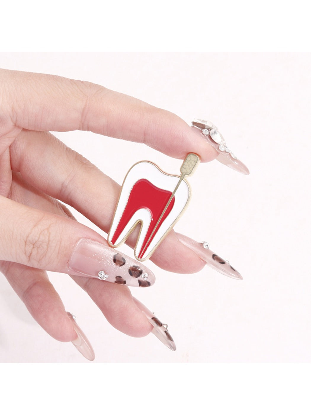 Close-up of Pinori tooth nerve theme pin showing intricate enamel and metal design