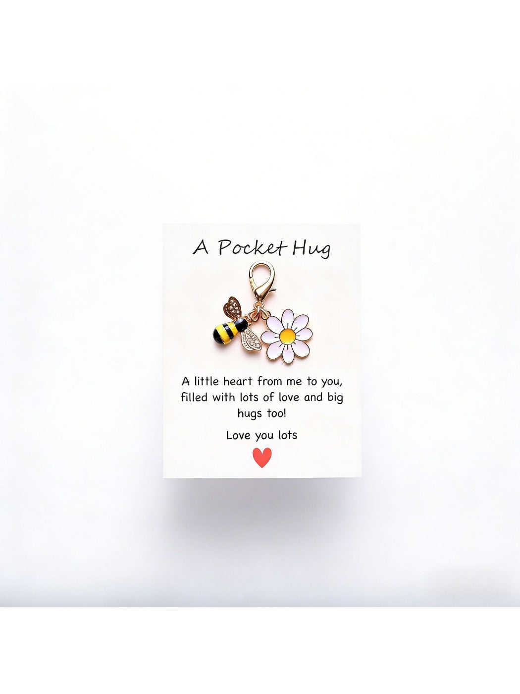 Taphug Pocket Hug Daisy Keychain with white daisy charm and gold ring on a reflective surface