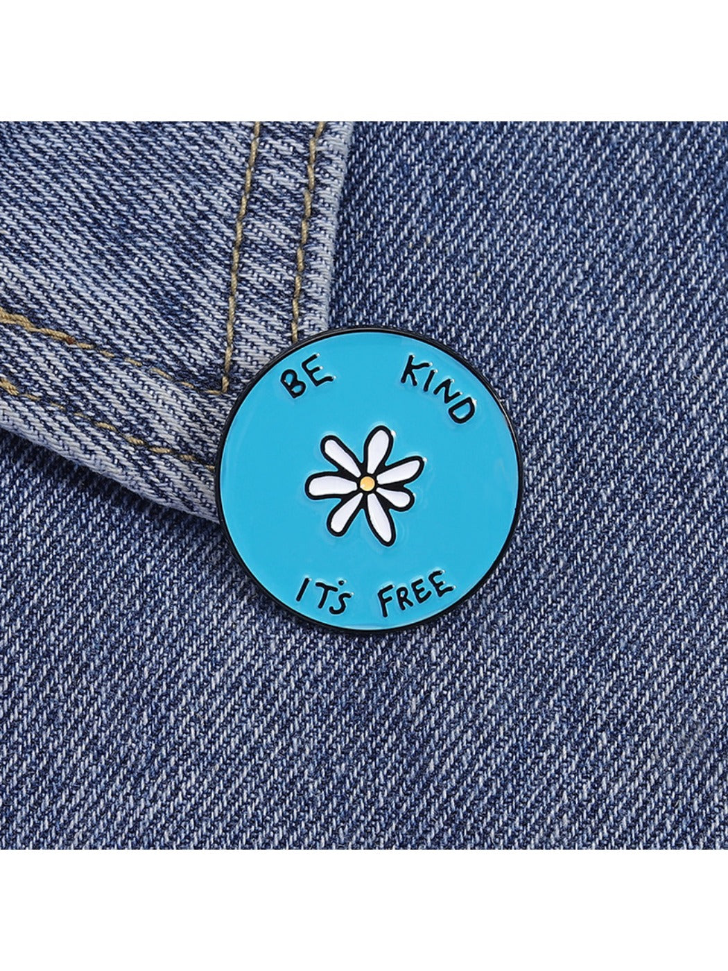 Pinori brooch with white flower and alphabet on blue round base displayed flat