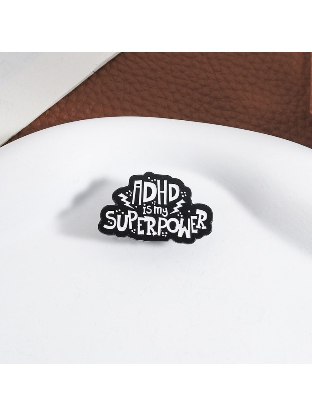 Side view of Pinori pin badge highlighting metal pin backing and clasp