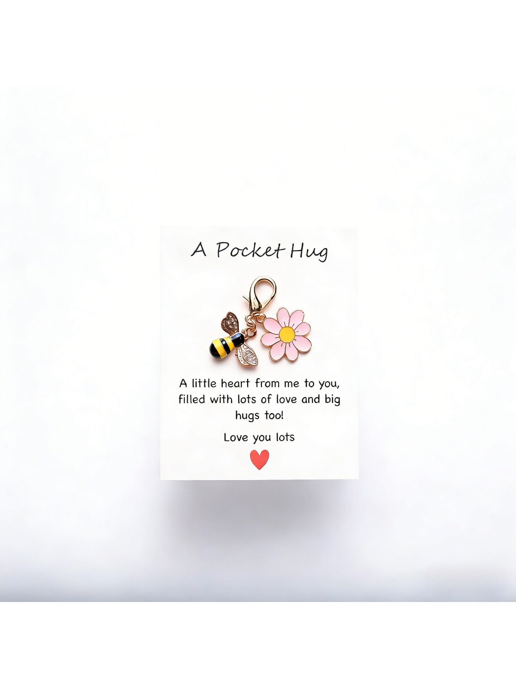Taphug Pocket Hug Daisy Keychain shown with daisy charm and gold ring on a light fabric