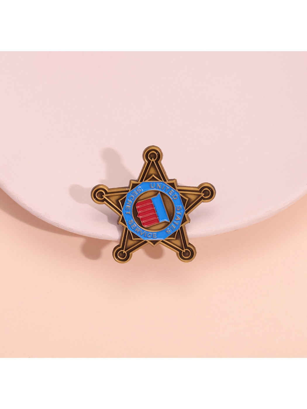 Close-up of Pinori retro five point star brooch with gold-tone finish