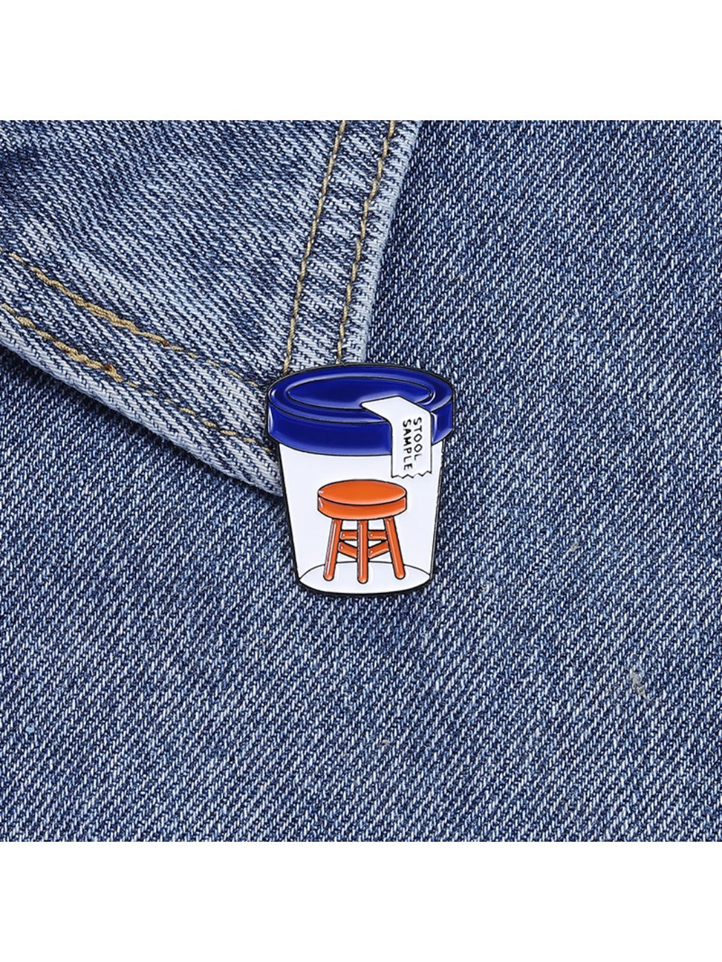 Close-up of Pinori stool sample bottle pin badge showing detailed design