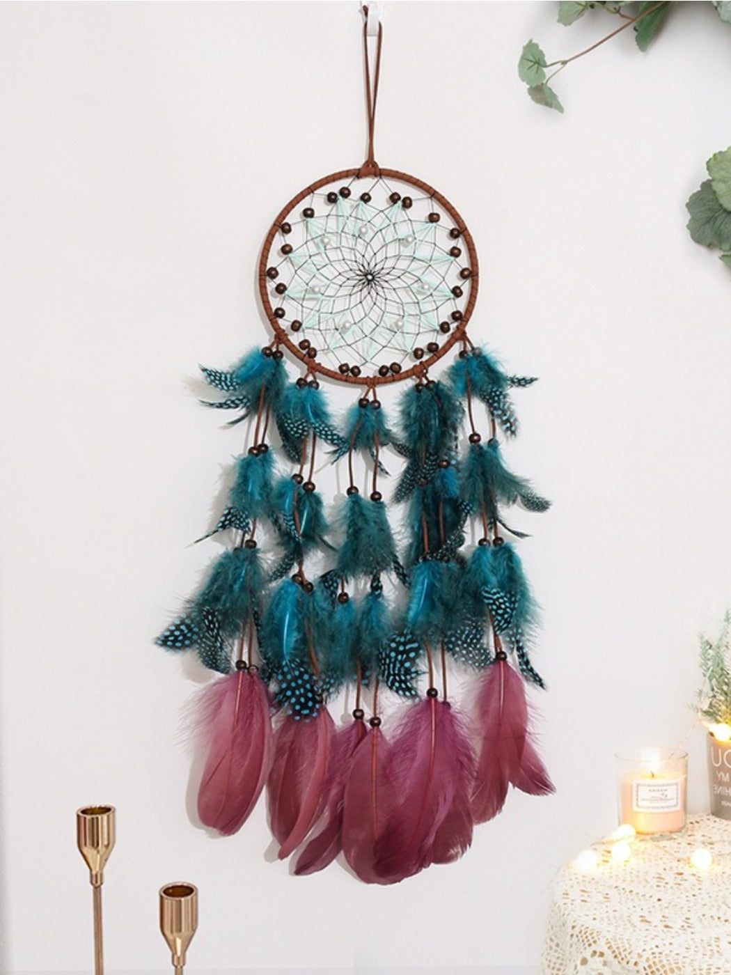 Bohemian style Somnira dream catcher with hanging feathers and beads on wooden background