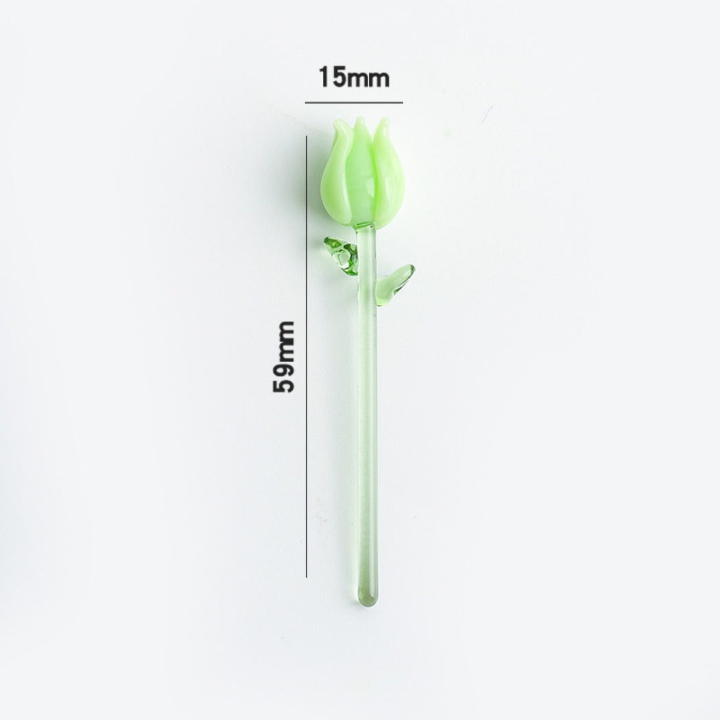 Glass rose with pink petals and green stem displayed against a soft blurred background
