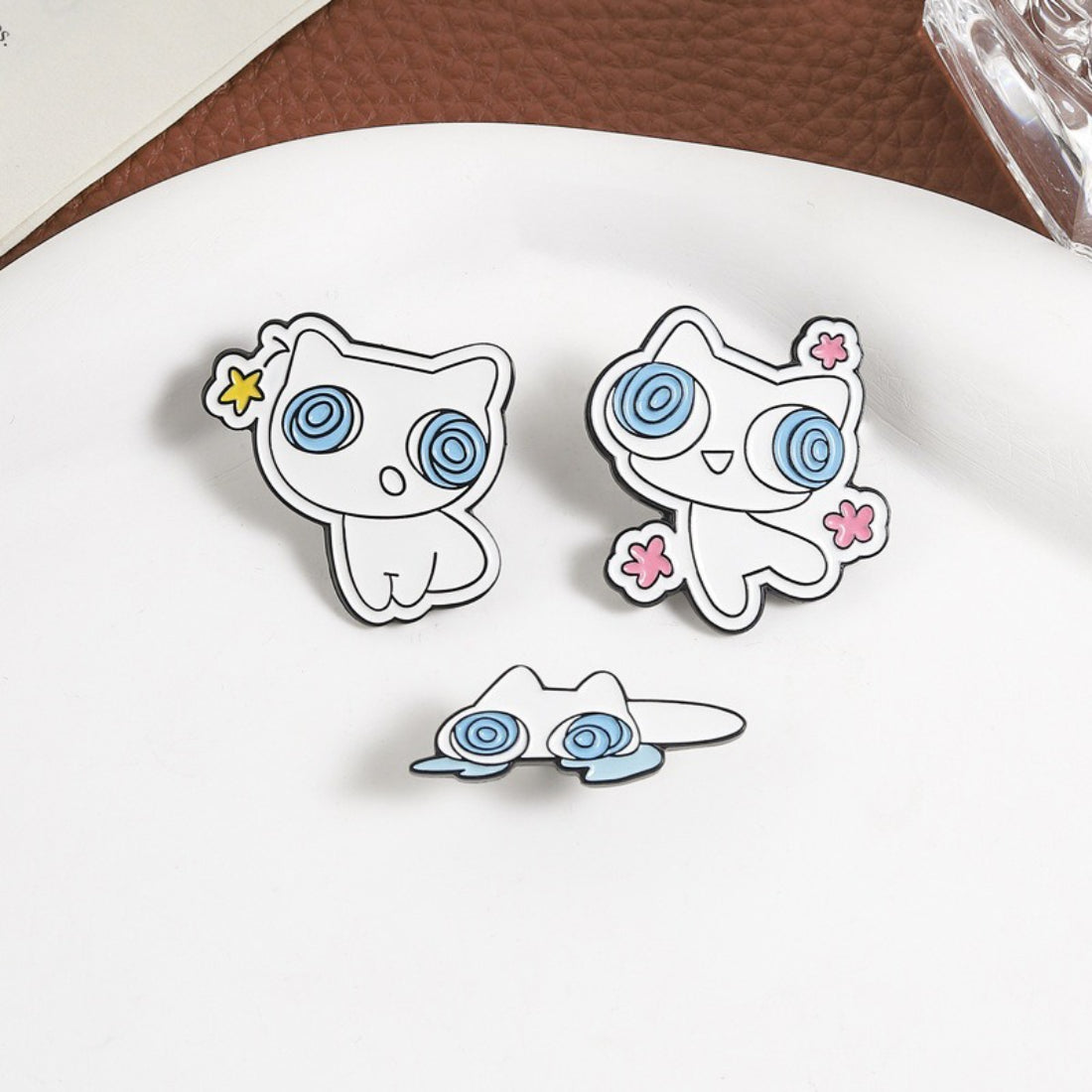 Close-up of Pinori Dizzy Eye White Cat enamel pin showing detailed cat face
