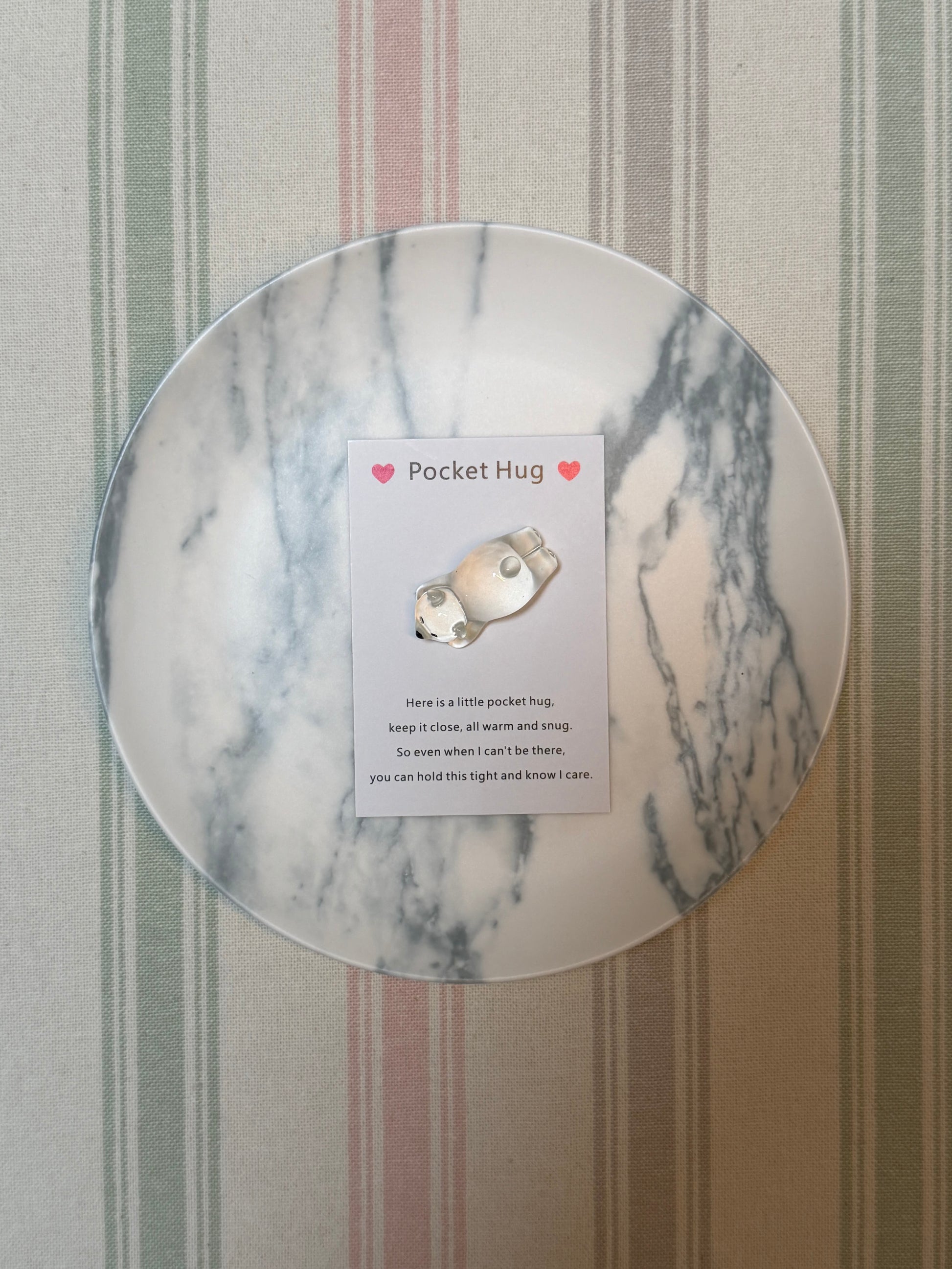 Group of pocket hug items laid out including card and polar bear token