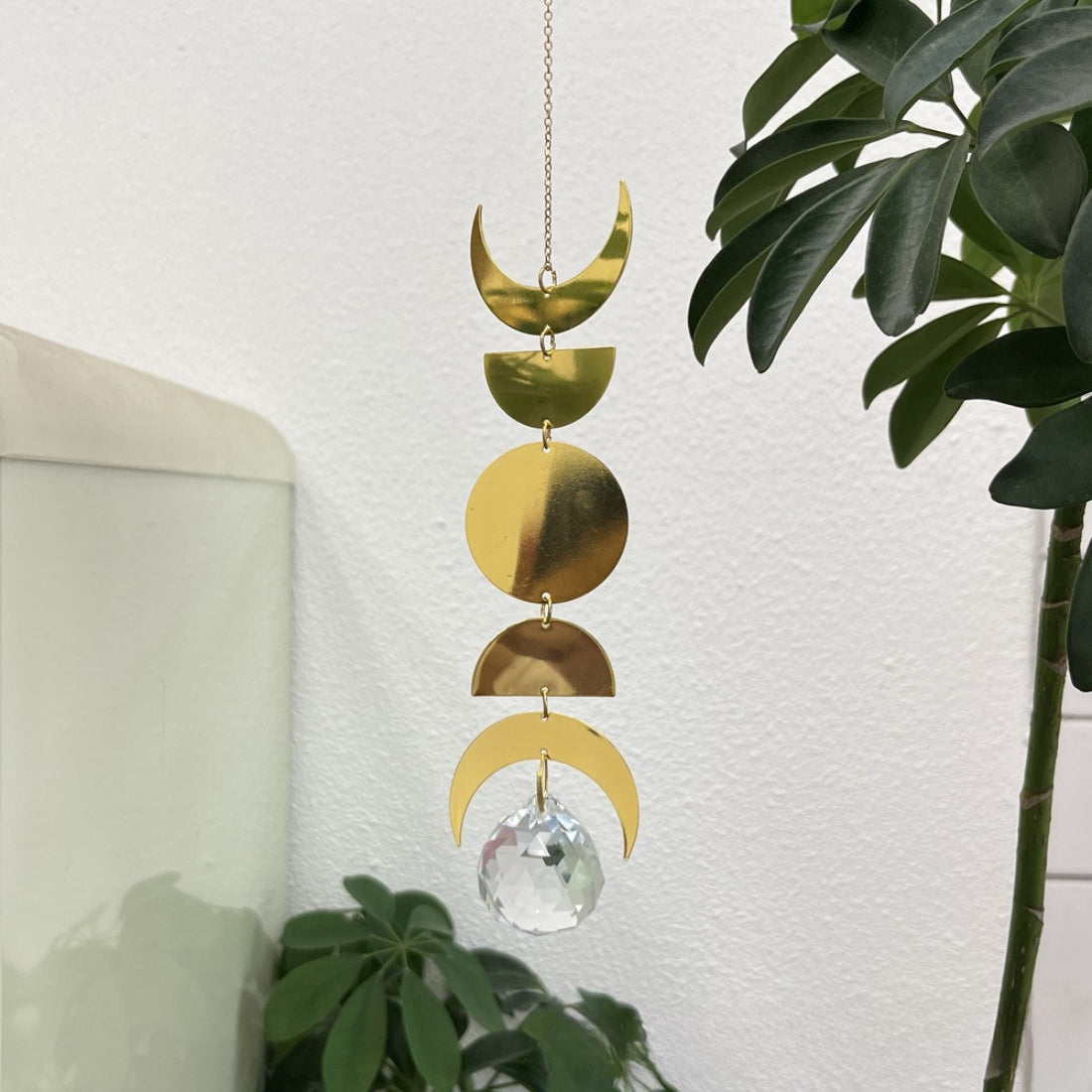 Close-up of Somnira Moon Phase suncatcher showing detailed moon phases in metal frame