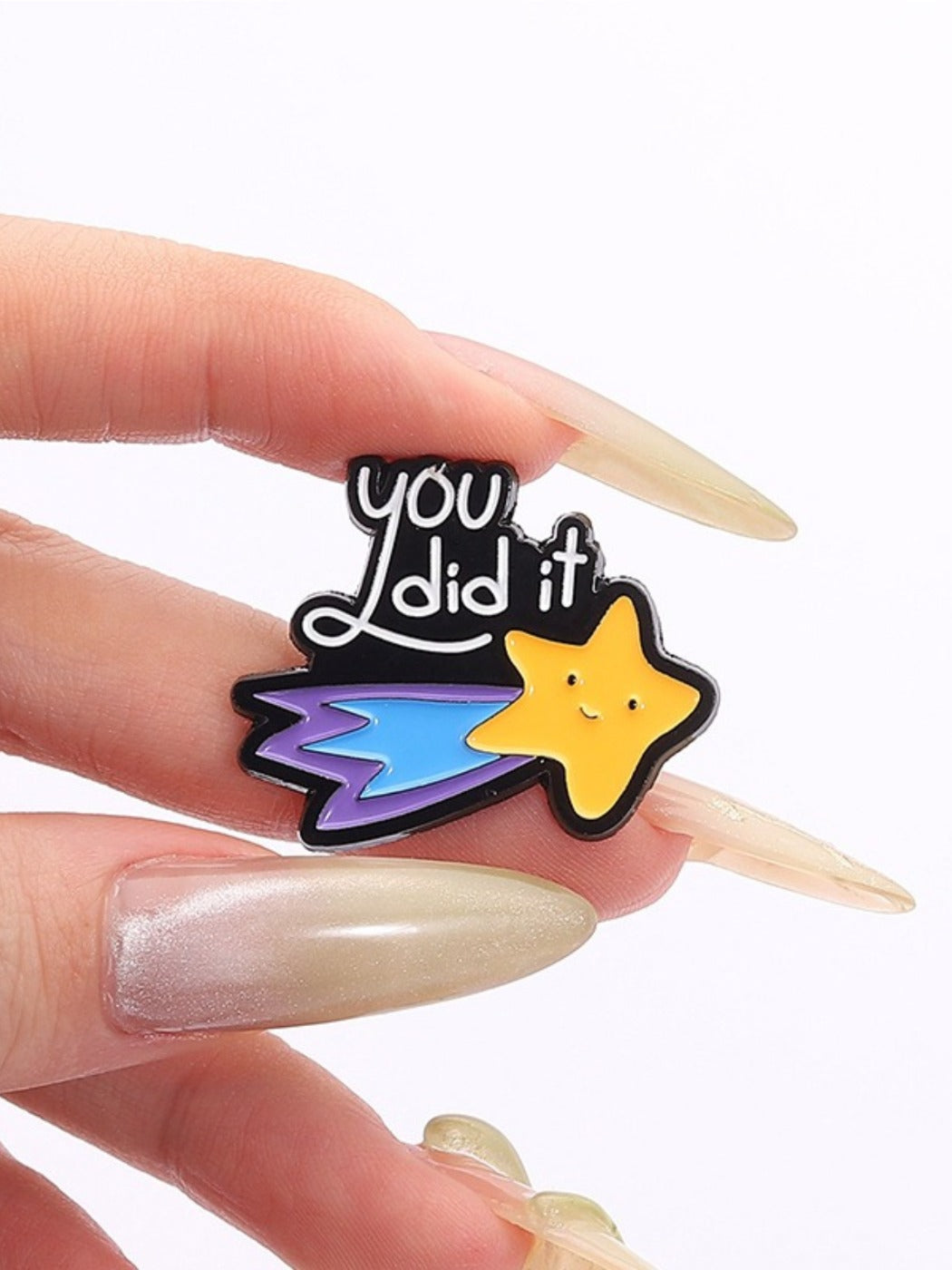 Pinori meteor shaped brooch resting on a wooden table with soft shadows