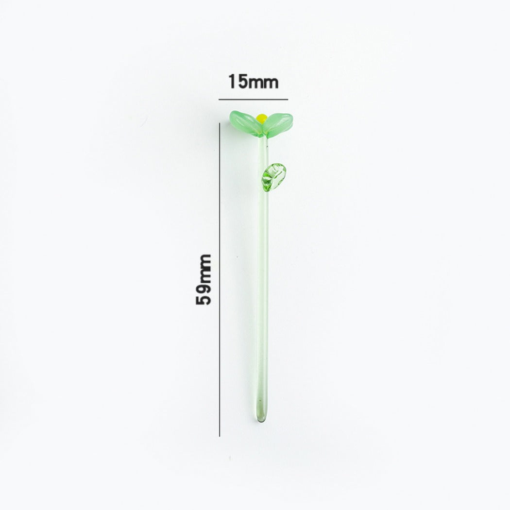 Thimara mini glass daisy placed next to a ruler for size reference