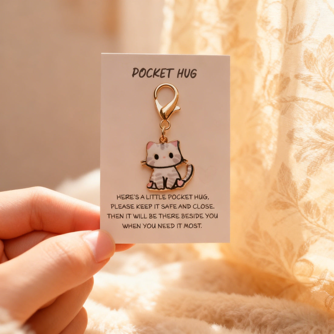 Taphug Kitten Charm Pocket Hug next to a smartphone for size comparison