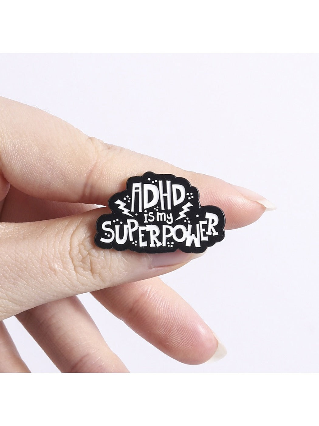 Pinori pin badge displayed on a denim jacket pocket with 'ADHD Is My Superpower' text