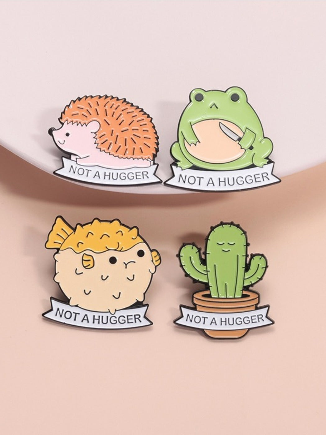 Close-up of whimsical frog sitting on a green puffer cactus enamel pin