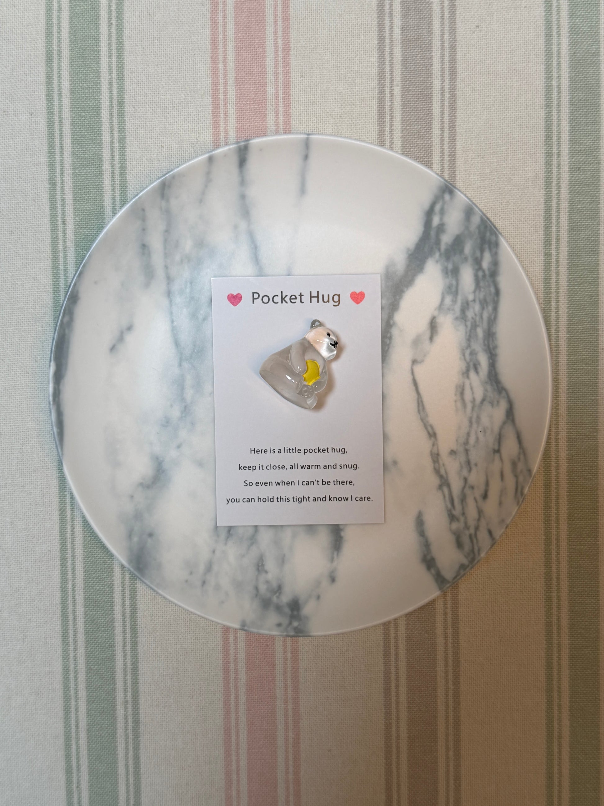 Pocket hug card partially open with polar bear token beside it