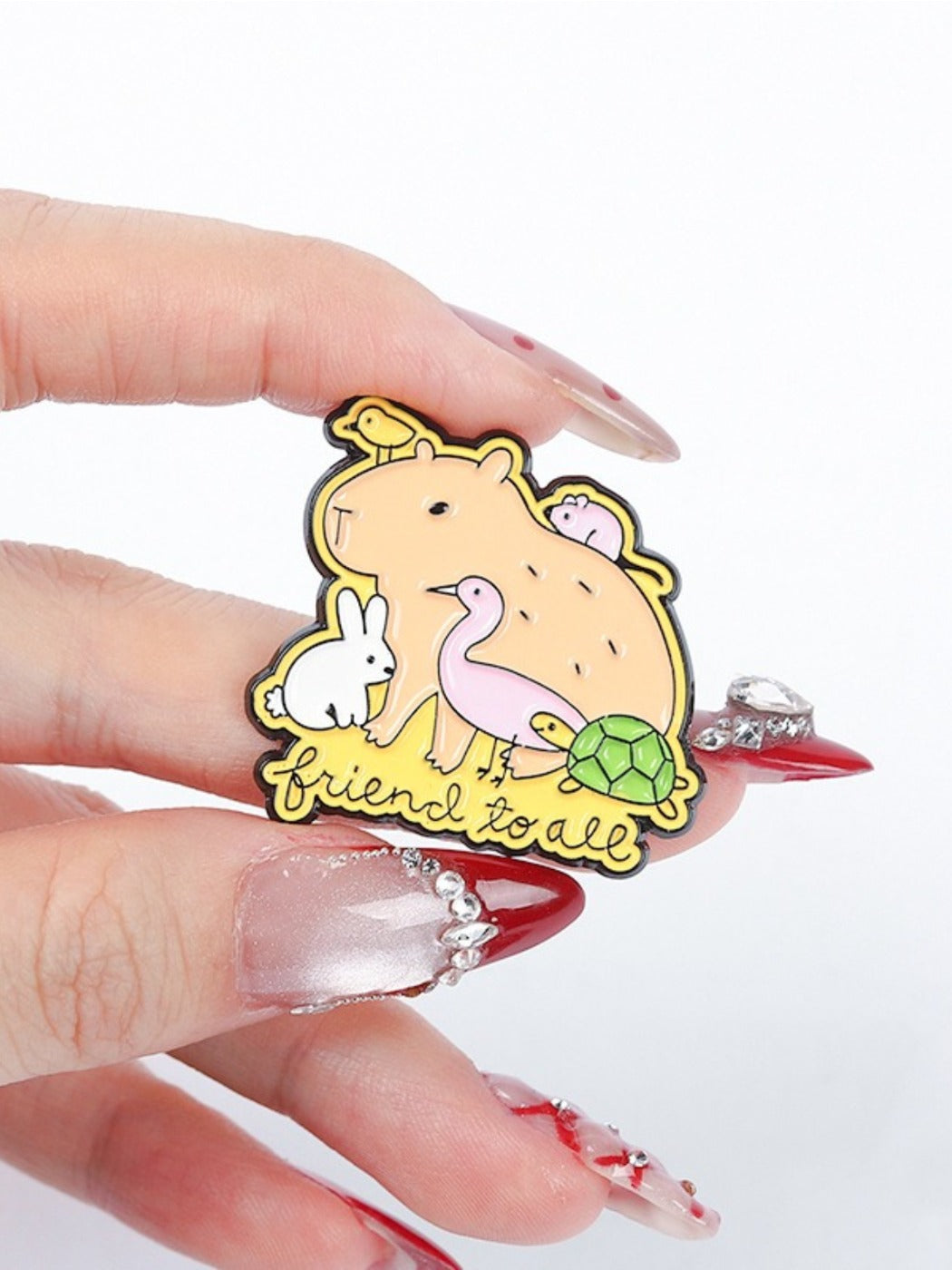Pinori capybara brooch placed on fabric, showing size and design
