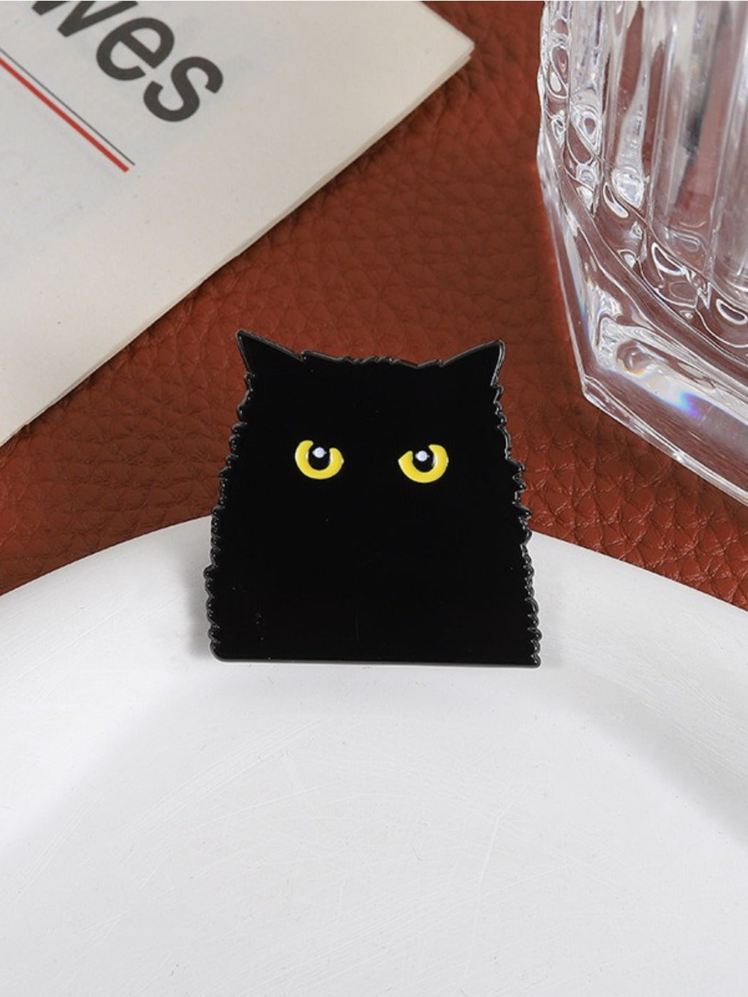 Pinori black cat brooch attached to a denim jacket pocket