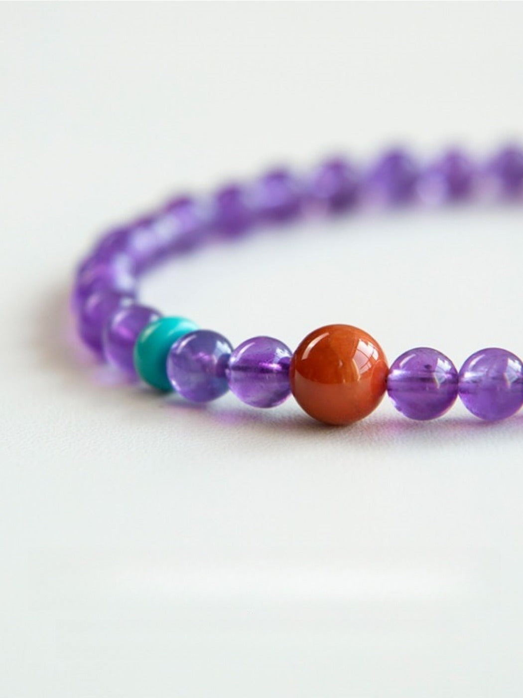 Emora bracelet featuring polished lavender amethyst stones and purple beads displayed on a hand