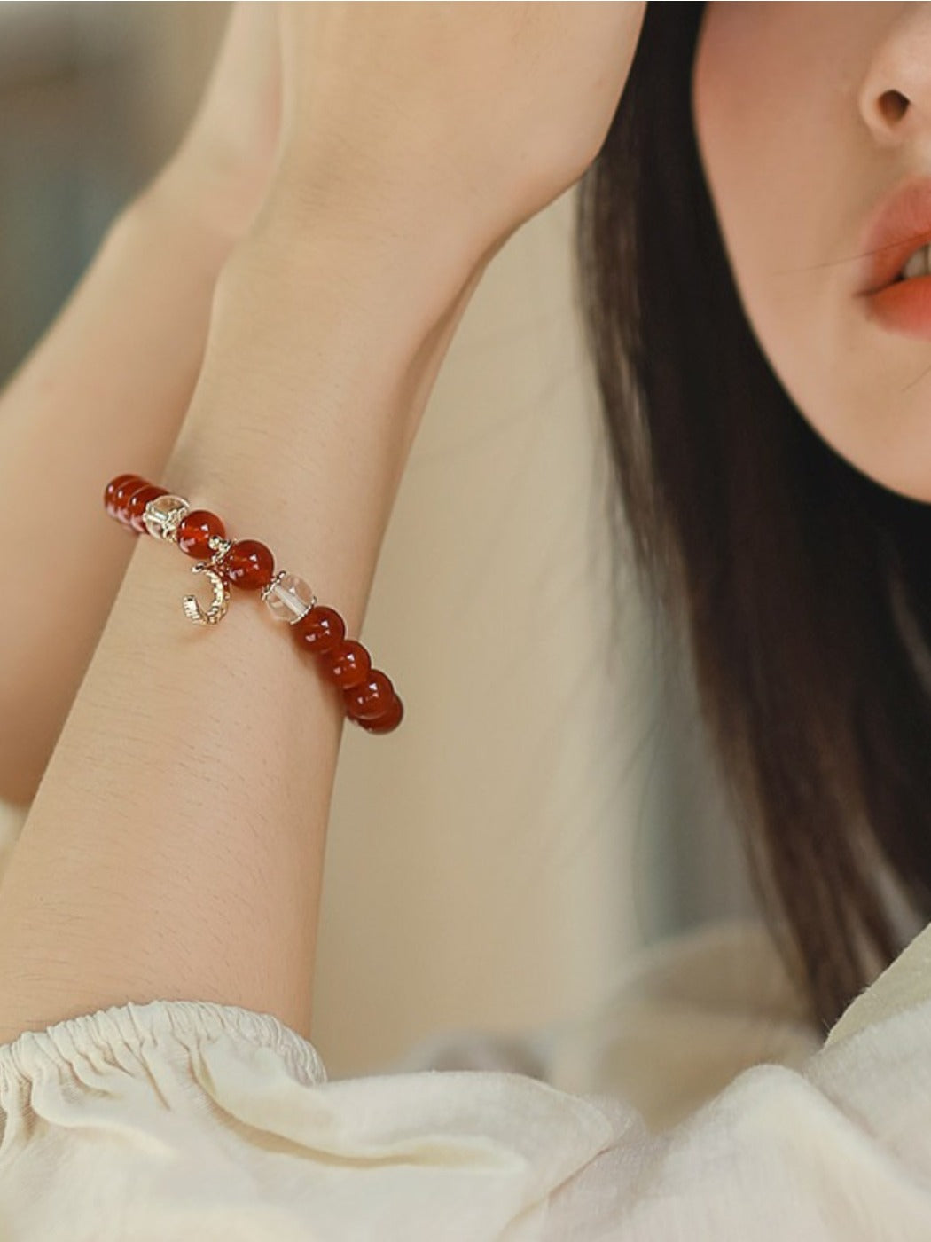 Red agate bracelet styled with casual outfit on a model's wrist