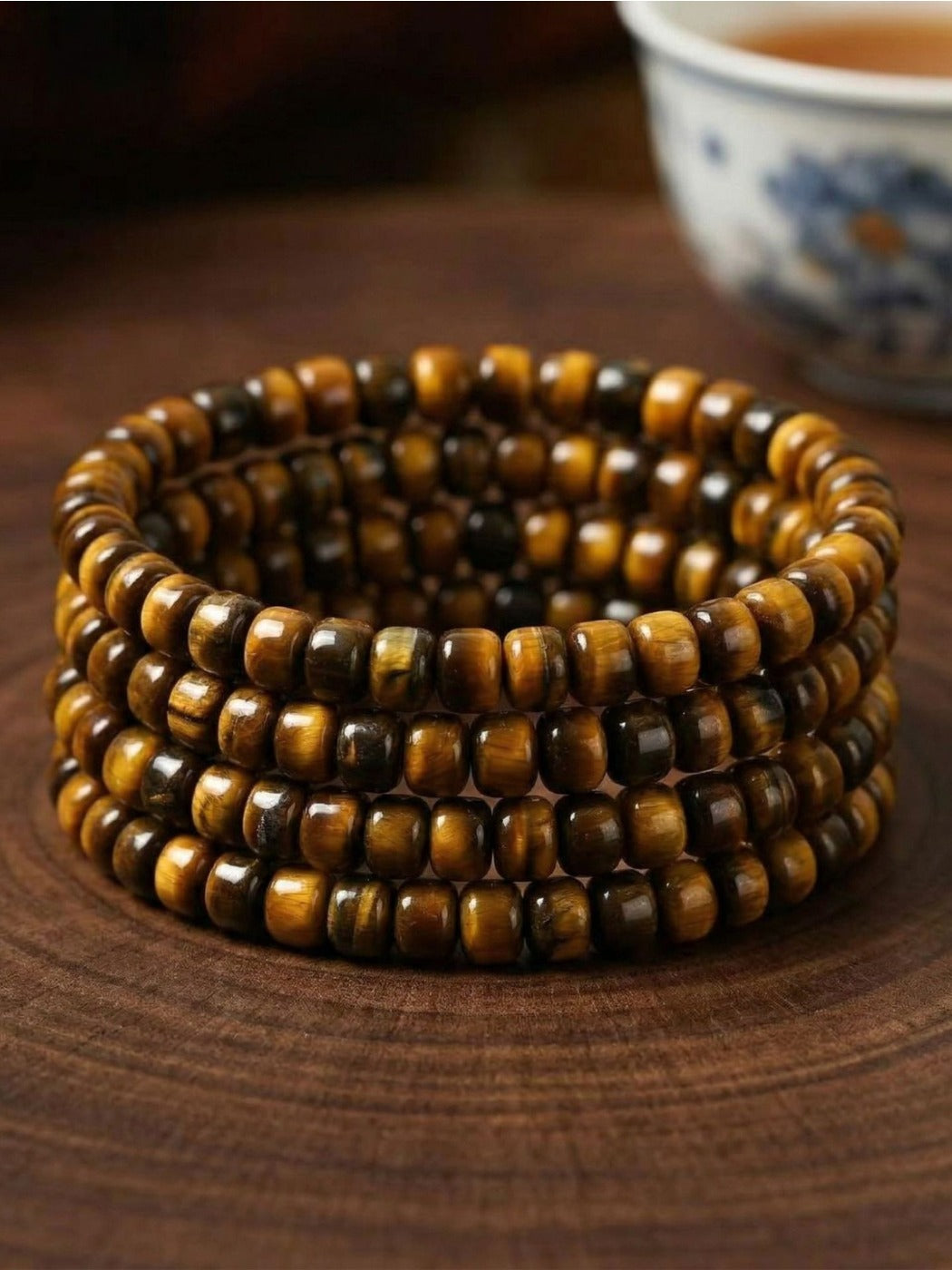 Emora tiger eye beaded bracelet displayed on a wooden surface showing bead texture