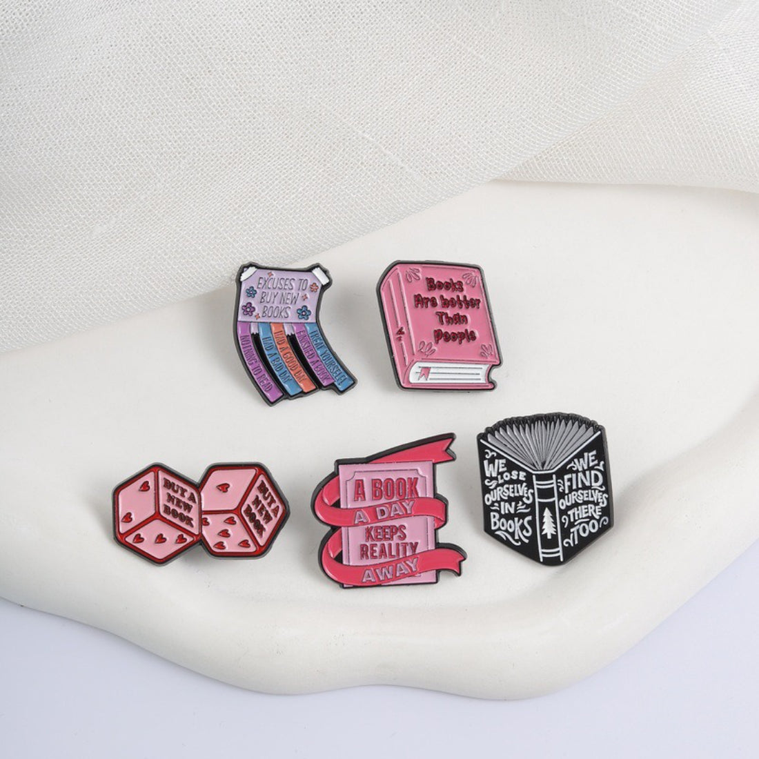 Pinori Book Lover enamel pin displayed on a denim jacket pocket