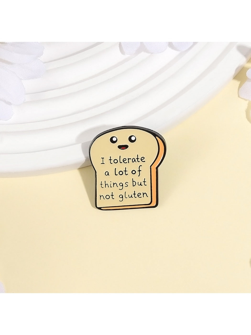 Close-up of Pinori bread cartoon pin showing smiling face details