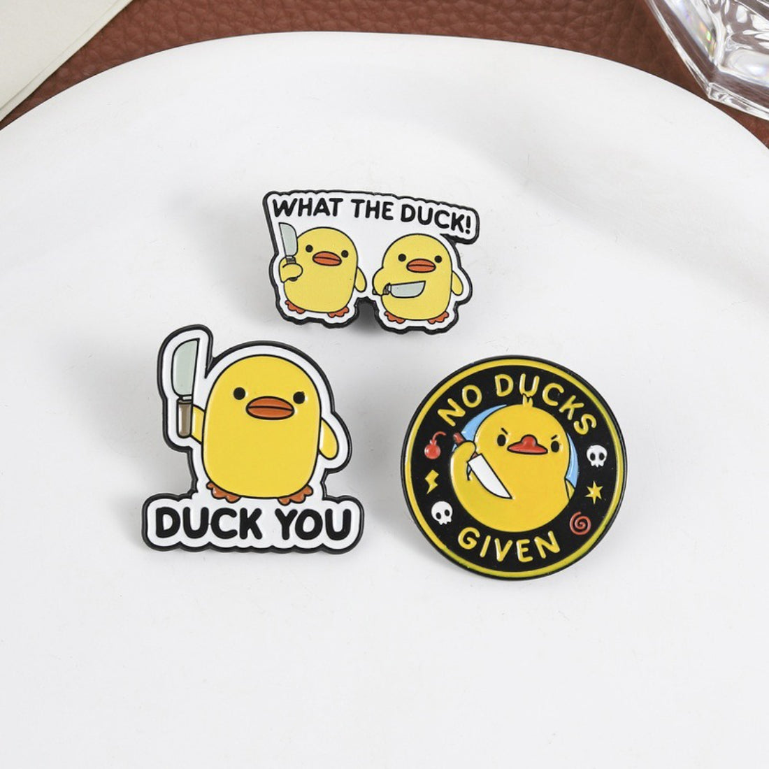 Pinori duck enamel pin attached to denim fabric highlighting size and design