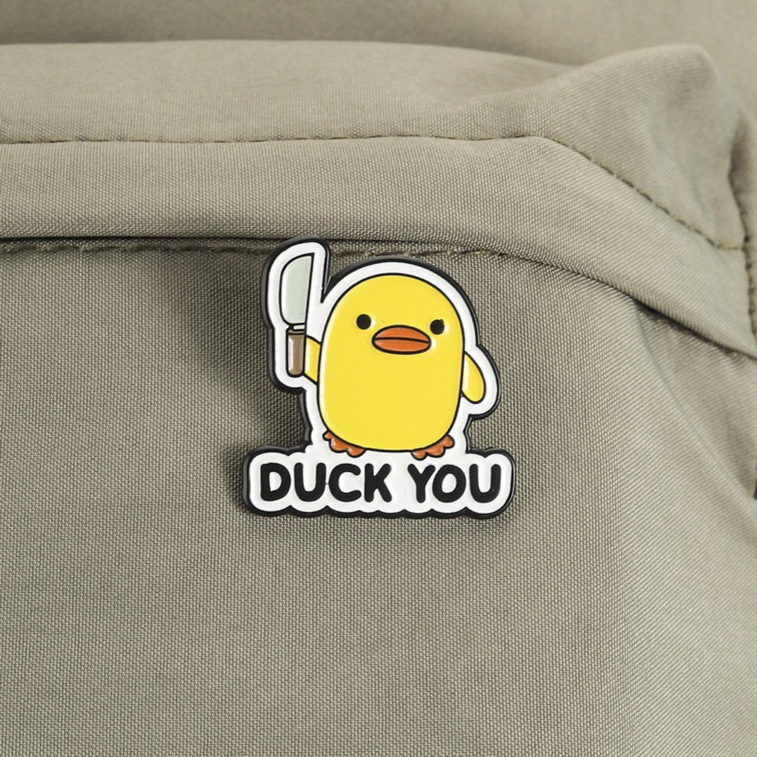 Close-up of Pinori duck enamel pin showing detailed facial features and metal outline